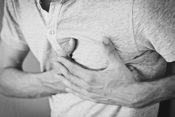 When Your Heart Cries Out for Help: Identifying and Treating a Heart Attack Black and white photo of a man clutching his chest, indicating discomfort or pain.