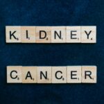 Close-up of the words 'Kidney Cancer' in Scrabble tiles on a dark blue background.